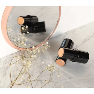 Premium MIANIMED skincare products reflected in a marble mirror with flowers.